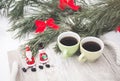 Two coffee cups and toy snowmen are standing at winter picnic outdoors. Pine tree and wooden tray on the snow in forest. Happy Royalty Free Stock Photo