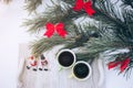 Two coffee cups and toy snowmen are standing at winter picnic outdoors. Pine tree and wooden tray on the snow in forest. Happy Royalty Free Stock Photo