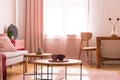 Two coffee cups on wooden coffee table in chic pastel pink living room