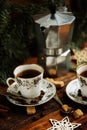 Two cups of espresso with pieces of cane sugar and Italian coffee maker on wooden table. Royalty Free Stock Photo