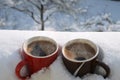 Two coffee mugs in snow