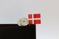 Two coins Danish Kroner money and mini Denmark flag stick on the black wallet with white background Royalty Free Stock Photo