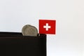 Two coins of one swiss Franc and mini Switzerland flag stick on the black wallet with white background. Franc Schweiz money Royalty Free Stock Photo