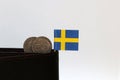 Two coins Swedish Krona money and mini Sweden flag stick on the black wallet with white background Royalty Free Stock Photo