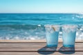 Two cold beverages on a wooden deck by the sea Royalty Free Stock Photo