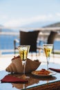 Two cold glasses of iced tea, white wine with ice cubes and a greek traditional snack with a Greek Fava on a table at a