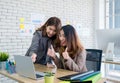 Two colleague businesswoman thumbs up for good job on laptop about work at office.Digital business lifestyle concept. Royalty Free Stock Photo