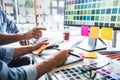 Two colleague creative graphic designer working on color selection and color swatches, drawing on graphics tablet at workplace Royalty Free Stock Photo