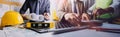 Two colleagues discussing data working and tablet, laptop with on on architectural project at construction site at desk in office Royalty Free Stock Photo