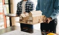 Two colleagues discussing data working and tablet, laptop with on architectural project at construction site at desk Royalty Free Stock Photo