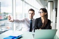 Two colleagues friends taking the picture to them self sitting in the office, man and woman taking selfie with telephone camera, w Royalty Free Stock Photo