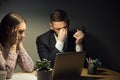 Two colleagues meeting in dark evening office to solve a problem