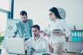 Two colleagues are standing next to the new one, sitting, looking at the laptop screen. Help, unity, tteam work concept, all in f Royalty Free Stock Photo