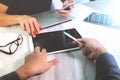 two colleagues website designer discussing data and digital tablet and computer laptop and smart phone on marble desk as Royalty Free Stock Photo