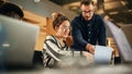 Two Colleagues Working On Laptop in Office. Female Hispanic Help Desk Coordinator Collaborates with Royalty Free Stock Photo