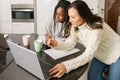 Two college girls studying together at home with laptops while drinking coffee Royalty Free Stock Photo