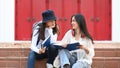 Two college student reading interesting book and prepare for exam while standing together in the campus. Royalty Free Stock Photo