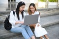 Two college student sitting on the stairs, working and looking something on laptop Royalty Free Stock Photo