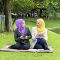 Two college students having discussion and changing ideas while sitting in the park