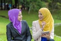 Two college students having discussion and changing ideas while sitting in the park