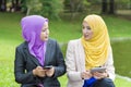 Two college students having discussion and changing ideas while sitting in the park