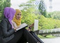 Two college students having discussion and changing ideas while sitting in the park