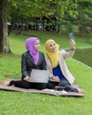 Two college students taking photo in the park