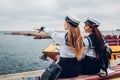 Two college women students of Marine academy walking by sea wearing uniform. Friends pointing into distance on pier Royalty Free Stock Photo