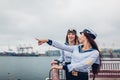 Two college women students of Marine academy walking by sea wearing uniform. Friends pointing into distance on pier Royalty Free Stock Photo