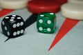 Two colored dice on backgammon board with backgammon pieces in the background Royalty Free Stock Photo