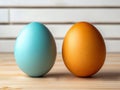 Two colored eggs sitting next to each other on a wooden table Royalty Free Stock Photo