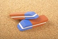 Two colored erasers on cork board Royalty Free Stock Photo