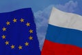 Two colored flags on torn fabric, a symbol of international relations between the European Union and Russia, the concept of global Royalty Free Stock Photo