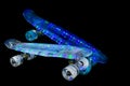 Two colored skateboards in dynamics, movement on a black background, beautiful multi-colored lights Royalty Free Stock Photo