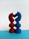 Two colorful Abstract chess pieces cuddling each other on a blue and white background for the concept of love Royalty Free Stock Photo