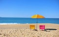 Two colorful beach chairs and umbrella with blue sea water Royalty Free Stock Photo