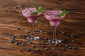 Two colorful blueberry smoothie cocktails in margarita glasses on a wooden background. Refreshing summer beverages. Copy space. Royalty Free Stock Photo