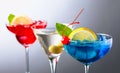 Two colorful cocktails and dry martini with green olives Royalty Free Stock Photo