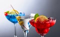 Two colorful cocktails and dry martini with green olives Royalty Free Stock Photo