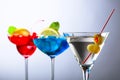 Two colorful cocktails and dry martini with green olives Royalty Free Stock Photo