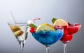 Two colorful cocktails and dry martini with green olives Royalty Free Stock Photo