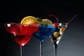 Two colorful cocktails and dry martini with green olives Royalty Free Stock Photo