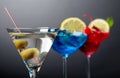 Two colorful cocktails and dry martini with green olives Royalty Free Stock Photo