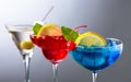 Two colorful cocktails and dry martini with green olives Royalty Free Stock Photo