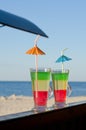 Two colorful cocktails with straws on the background of the beach Royalty Free Stock Photo