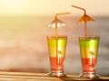 Two colorful cocktails in the sunset on the sea background, close up Royalty Free Stock Photo