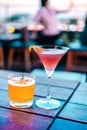 Two colorful cocktails on a wooden table of a bar. Royalty Free Stock Photo