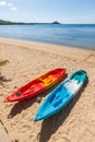 Two colorful empty canoe on the beach.