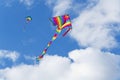 Two colorful kites in a blue sky with white clouds Royalty Free Stock Photo