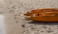 Two colorful orange kayaks on a sandy beach ready for paddlers in sunny day. Several orange recreational boats on the Royalty Free Stock Photo